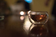 Transparent small glass of Chinese black tea on a table, shot co royalty free stock image Transparent small glass of Chinese black tea on a table, shot co royalty free stock image