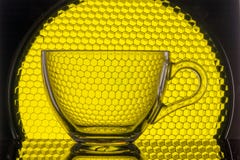transparenter Becher auf einem Hintergrund der gelben Bienenwabe für Fotografie stockbild transparenter Becher auf einem Hintergrund der gelben Bienenwabe für Fotografie stockbild