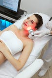 Tratamento claro conduzido vermelho Mulher que faz a terapia facial da pele imagem de stock Tratamento claro conduzido vermelho Mulher que faz a terapia facial da pele imagem de stock