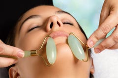 Tratamento facial da beleza com rolos do jade foto de stock royalty free Tratamento facial da beleza com rolos do jade foto de stock royalty free