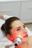 Tratamento facial da beleza Mulher que faz a terapia clara conduzida vermelha fotografia de stock royalty free Tratamento facial da beleza Mulher que faz a terapia clara conduzida vermelha fotografia de stock royalty free