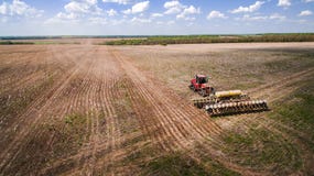 Trator que prepara a terra para semear dezesseis fileiras aéreas, conceito do cultivo, sementeira, arando o campo, o trator e o a foto de stock Trator que prepara a terra para semear dezesseis fileiras aéreas, conceito do cultivo, sementeira, arando o campo, o trator e o a foto de stock