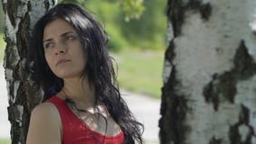 Traurige Frau nach defekten Verhältnissen, allein im Park unter Baum schaut weg langsam stock video Traurige Frau nach defekten Verhältnissen, allein im Park unter Baum schaut weg langsam stock video