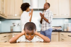 Trauriger Junge gegen die Elternargumentierung Lizenzfreies Stockfoto Trauriger Junge gegen die Elternargumentierung Lizenzfreies Stockfoto