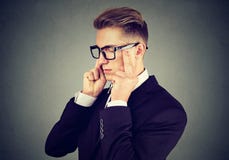 Trauriger junger Geschäftsmann mit dem besorgten betonten Gesichtsausdruck, der unten schaut lizenzfreie stockfotografie Trauriger junger Geschäftsmann mit dem besorgten betonten Gesichtsausdruck, der unten schaut lizenzfreie stockfotografie
