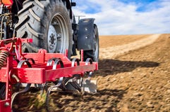 Travail de tracteur dans le domaine Roues de tracteur et haut étroit d'équipement photos stock Travail de tracteur dans le domaine Roues de tracteur et haut étroit d'équipement photos stock
