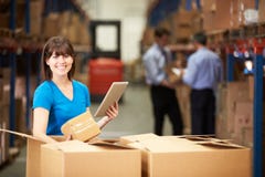 Travailleur dans des boîtes de vérification d'entrepôt utilisant la Tablette de Digital Travailleur dans des boîtes de vérification d'entrepôt utilisant la Tablette de Digital