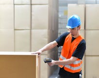 Travailleur de logistique - l'homme balaye des colis des marchandises et prépare le d photographie stock libre de droits Travailleur de logistique - l'homme balaye des colis des marchandises et prépare le d photographie stock libre de droits