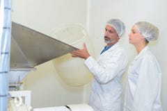 Travailleurs ajoutant le matériel dans l'usine images libres de droits Travailleurs ajoutant le matériel dans l'usine images libres de droits