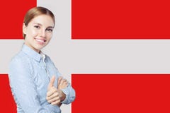 Travel and learn danish language concept. Happy Smiling woman student showing thumb up against the Denmark flag background stock images Travel and learn danish language concept. Happy Smiling woman student showing thumb up against the Denmark flag background stock images
