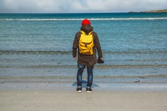 Traveler is a professional photographer taking over the landscape photo landscape. Wearing a yellow backpack in a red stock image Traveler is a professional photographer taking over the landscape photo landscape. Wearing a yellow backpack in a red stock image