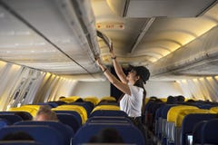 Traveller woman open overhead locker on airplane royalty free stock images Traveller woman open overhead locker on airplane royalty free stock images