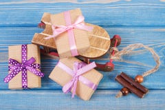 Traîneau en bois et cadeaux enveloppés avec des rubans pour Noël ou toute autre célébration sur les conseils bleus Photographie stock Traîneau en bois et cadeaux enveloppés avec des rubans pour Noël ou toute autre célébration sur les conseils bleus Photographie stock