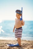 Tre anni del ragazzo che gioca alla spiaggia con l'anello di nuoto immagini stock Tre anni del ragazzo che gioca alla spiaggia con l'anello di nuoto immagini stock