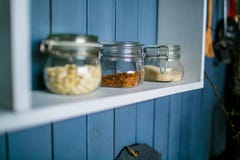 Tre barattoli trasparenti per alimento sullo scaffale bianco nella cucina immagine stock Tre barattoli trasparenti per alimento sullo scaffale bianco nella cucina immagine stock