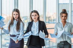 Tre giovani belle signore castane di affari nell'ufficio Tutto il serio, parlando a vicenda fotografia stock Tre giovani belle signore castane di affari nell'ufficio Tutto il serio, parlando a vicenda fotografia stock