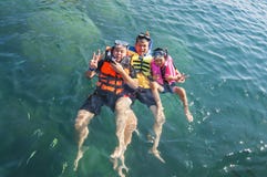 Tre tipi che galleggiano felicemente nel mare fotografia stock libera da diritti Tre tipi che galleggiano felicemente nel mare fotografia stock libera da diritti