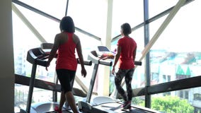 Ελκυστικό καυκάσιο κορίτσι που τρέχει treadmill στην αθλητική γυμναστική με το τηλέφωνο και τα ακουστικά Κάμερα σε 4K απόθεμα βίντεο Ελκυστικό καυκάσιο κορίτσι που τρέχει treadmill στην αθλητική γυμναστική με το τηλέφωνο και τα ακουστικά Κάμερα σε 4K απόθεμα βίντεο