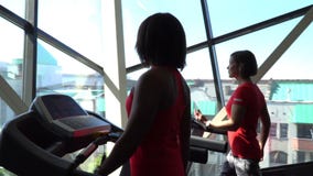 Ελκυστικό καυκάσιο κορίτσι που τρέχει treadmill στην αθλητική γυμναστική με το τηλέφωνο και τα ακουστικά Κάμερα σε 4K απόθεμα βίντεο Ελκυστικό καυκάσιο κορίτσι που τρέχει treadmill στην αθλητική γυμναστική με το τηλέφωνο και τα ακουστικά Κάμερα σε 4K απόθεμα βίντεο