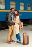 Treffen nach einer Reise eines glücklichen Paars, das in der Straße in einer Bahnstation umarmt Warmes Sonnenlicht des schönen Ab lizenzfreies stockbild Treffen nach einer Reise eines glücklichen Paars, das in der Straße in einer Bahnstation umarmt Warmes Sonnenlicht des schönen Ab lizenzfreies stockbild