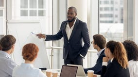 Treinador afro-americano que fala à audiência que dá a apresentação no flipchart fotos de stock Treinador afro-americano que fala à audiência que dá a apresentação no flipchart fotos de stock