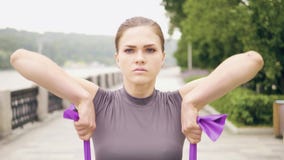 Treinamento da jovem mulher do retrato com o expansor da aptidão no parque do verão filme Treinamento da jovem mulher do retrato com o expansor da aptidão no parque do verão filme