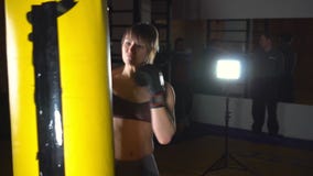 Treinamento fêmea do pugilista no clube do encaixotamento A mulher bonita dos esportes bate um saco de perfuração A mulher no gym video estoque Treinamento fêmea do pugilista no clube do encaixotamento A mulher bonita dos esportes bate um saco de perfuração A mulher no gym video estoque