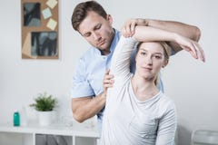 Treinamento masculino do fisioterapeuta com paciente imagem de stock Treinamento masculino do fisioterapeuta com paciente imagem de stock