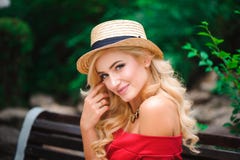 Trendig attraktiv blond kvinna i rött klänningsammanträde på stol royaltyfri foto Trendig attraktiv blond kvinna i rött klänningsammanträde på stol royaltyfri foto