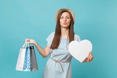 Trendig härlig kvinna för stående i sommarklänningen, sugrörhatt som rymmer packepåsar med köp, når att ha shoppat royaltyfri fotografi Trendig härlig kvinna för stående i sommarklänningen, sugrörhatt som rymmer packepåsar med köp, når att ha shoppat royaltyfri fotografi