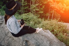 Trendy and attractive beautiful woman with analog vintage film camera makes photos on outdoor at sunset time royalty free stock photo Trendy and attractive beautiful woman with analog vintage film camera makes photos on outdoor at sunset time royalty free stock photo