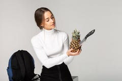 Trendy young girl holding in her hands pineapple with knife stock images Trendy young girl holding in her hands pineapple with knife stock images