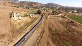 Treno passeggeri urbano moderno enorme che si muove attraverso il canyon asciutto del deserto nel paesaggio della steppa della sa archivi video Treno passeggeri urbano moderno enorme che si muove attraverso il canyon asciutto del deserto nel paesaggio della steppa della sa archivi video