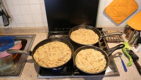 Tres cacerolas grandes con la comida nombraron frico un recip italiano típico Imagen de archivo libre de regalías Tres cacerolas grandes con la comida nombraron frico un recip italiano típico Imagen de archivo libre de regalías