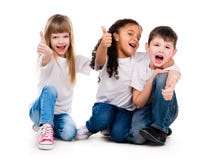 Tres niños divertidos que se sientan en el piso con los pulgares para arriba fotos de archivo Tres niños divertidos que se sientan en el piso con los pulgares para arriba fotos de archivo