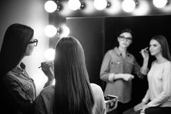 Trevlig attraktiv makeupkonstnär som ser in i spegeln royaltyfria bilder Trevlig attraktiv makeupkonstnär som ser in i spegeln royaltyfria bilder