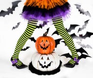 Trik eller fest Halloween ungar Randiga ben av lite häxaflickan med lyckliga smileypumpor royaltyfri fotografi Trik eller fest Halloween ungar Randiga ben av lite häxaflickan med lyckliga smileypumpor royaltyfri fotografi