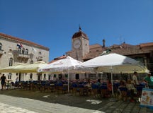 Trogir/Kroatien - 26. Juni 2017: Die Restauranttabellen im Freien auf Trogir-Quadrat im Stadtzentrum von Trogir lizenzfreies stockfoto Trogir/Kroatien - 26. Juni 2017: Die Restauranttabellen im Freien auf Trogir-Quadrat im Stadtzentrum von Trogir lizenzfreies stockfoto