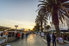 TROGIR, ΚΡΟΑΤΊΑ, ΤΗΝ 1Η ΟΚΤΩΒΡΊΟΥ 2017: Τουρίστες που περπατούν τα αγαθά μιας αγοράς στον έμπορο στην κεντρική οδό στο ηλιοβασίλε στοκ εικόνες TROGIR, ΚΡΟΑΤΊΑ, ΤΗΝ 1Η ΟΚΤΩΒΡΊΟΥ 2017: Τουρίστες που περπατούν τα αγαθά μιας αγοράς στον έμπορο στην κεντρική οδό στο ηλιοβασίλε στοκ εικόνες