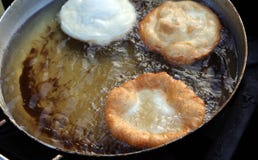 Trois crêpes ont fait cuire dans l'huile de ébullition d'un grand pot photos stock Trois crêpes ont fait cuire dans l'huile de ébullition d'un grand pot photos stock