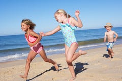 Trois enfants exécutant le long de la plage photographie stock libre de droits Trois enfants exécutant le long de la plage photographie stock libre de droits