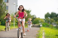 Trois enfants heureux montant sur la bicyclette photographie stock libre de droits Trois enfants heureux montant sur la bicyclette photographie stock libre de droits