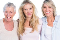 Trois générations des femmes gaies souriant à l'appareil-photo image stock Trois générations des femmes gaies souriant à l'appareil-photo image stock