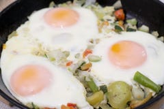 Trois oeufs avec des vegatables sur la poêle images stock Trois oeufs avec des vegatables sur la poêle images stock