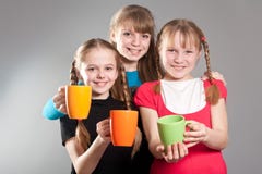 Trois petites filles mignonnes avec des tasses image stock Trois petites filles mignonnes avec des tasses image stock
