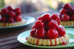 Trois tartes minuscules de fraise des plats verts photo stock Trois tartes minuscules de fraise des plats verts photo stock