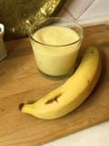 Tropicana-Smoothies mit Ananas, Banane und Kalk in der Kokosmilch lizenzfreies stockbild Tropicana-Smoothies mit Ananas, Banane und Kalk in der Kokosmilch lizenzfreies stockbild