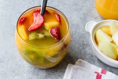 Tropisk coctailsangria med vitt vin, ananasfruktsaft, jordgubbar, kiwin, mango och Apple royaltyfria foton Tropisk coctailsangria med vitt vin, ananasfruktsaft, jordgubbar, kiwin, mango och Apple royaltyfria foton
