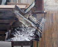 Trote fumate verticalmente e grigliate con gli spiedi di legno sopra la griglia fotografia stock Trote fumate verticalmente e grigliate con gli spiedi di legno sopra la griglia fotografia stock