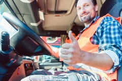 Truck driver sitting in cabin giving thumbs-up Royalty Free Stock Photography Truck driver sitting in cabin giving thumbs-up Royalty Free Stock Photography